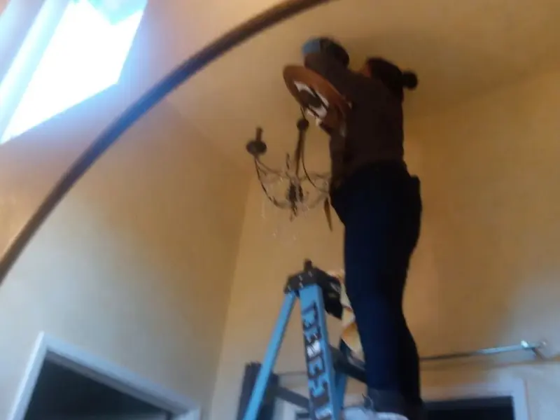 Electrician installing a chandelier in a Frankfort residence